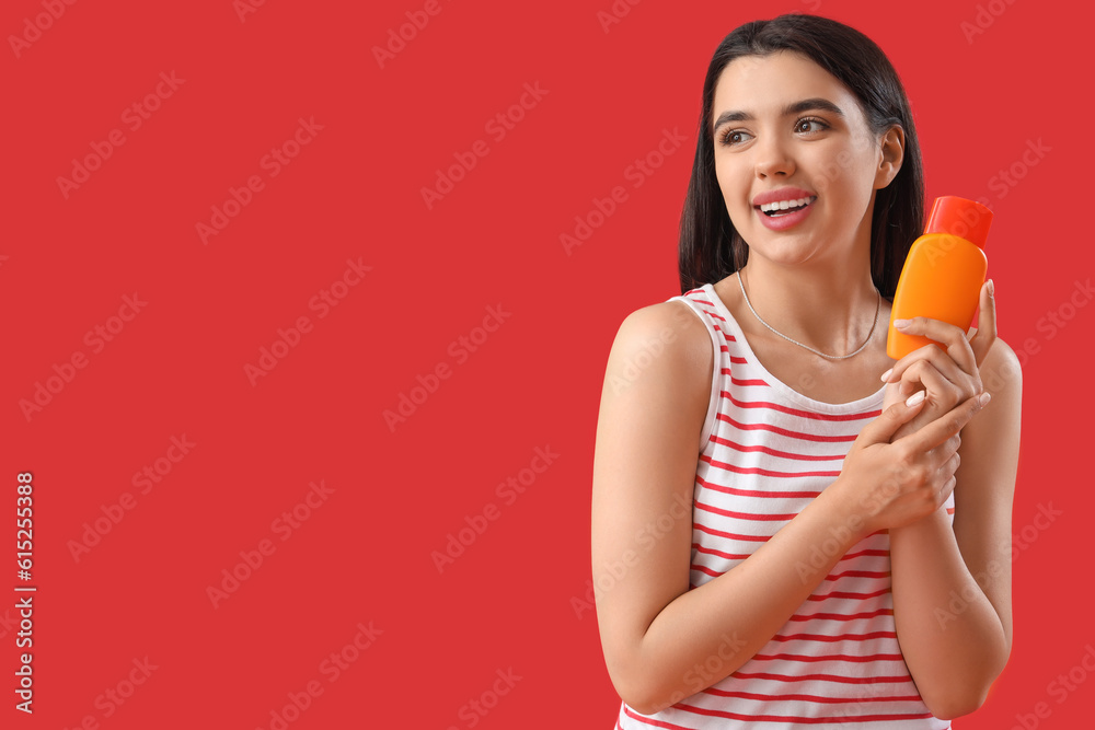 Young woman with sunscreen cream on red background Young woman with sunscreen cream on red background