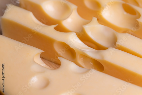 A cut piece of ripe cheese with lots of holes