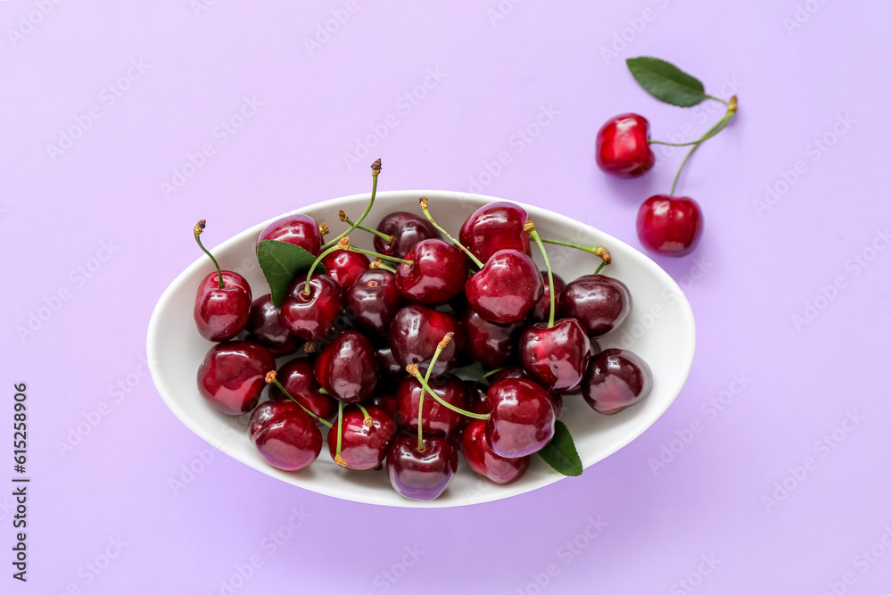 Bowl with sweet cherries on lilac background Bowl with sweet cherries on lilac background