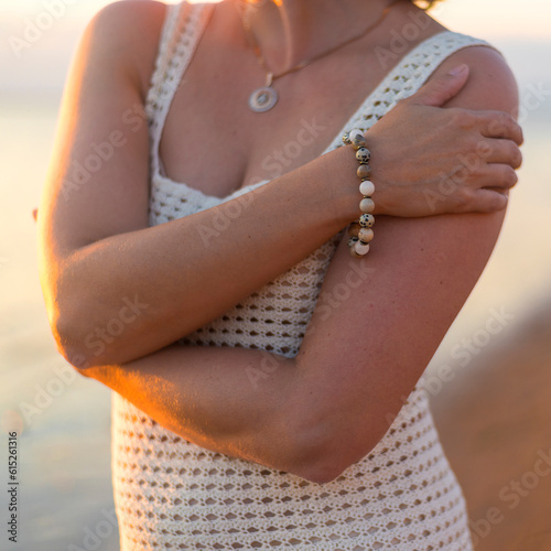 Canvas Print bracelet made of stones on a woman's hand on a background of sea