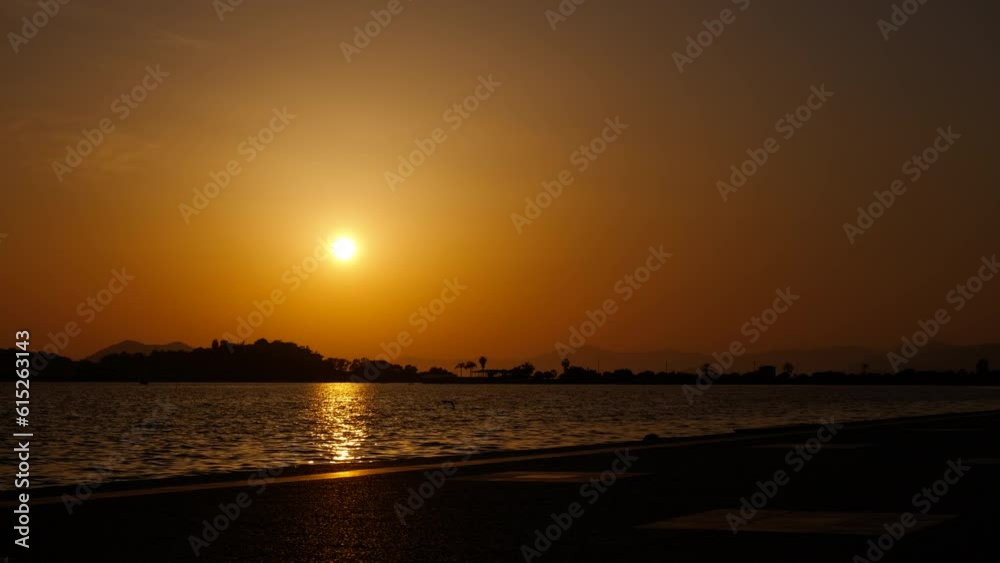 Empty river bank silhouette in evening. A view of empty river bank against colorful bright sky during summer time.