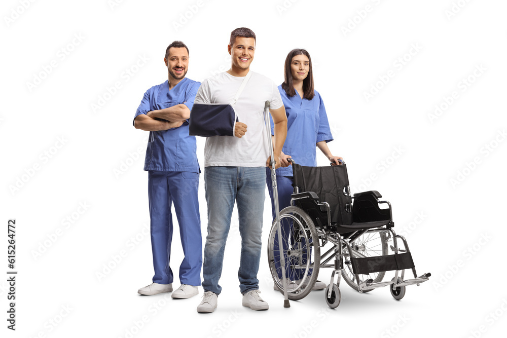 Young man with arm and leg injury standing with male and female health care workers Young man with arm and leg injury standing with male and female health care workers