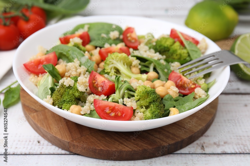 Healthy meal. Tasty salad with quinoa, chickpeas and vegetables on white wooden table, closeup