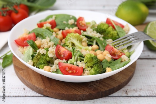Healthy meal. Tasty salad with quinoa, chickpeas and vegetables on white wooden table, closeup