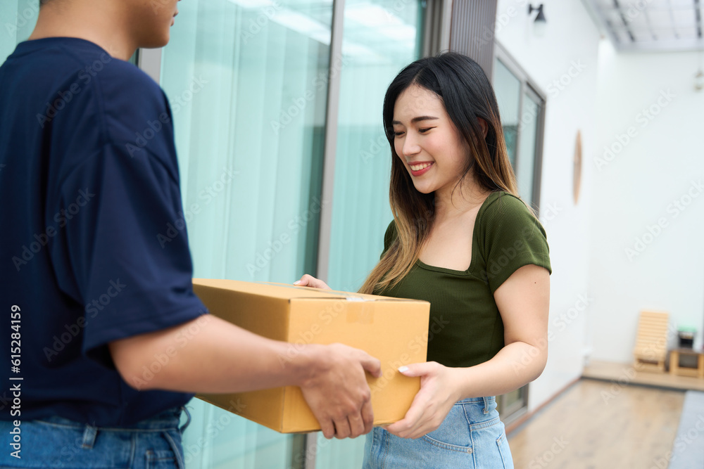 Woman receiving parcel from delivery man at the door. satisfied happy customer with online store order, good shipping delivery service Woman receiving parcel from delivery man at the door. satisfied happy customer with online store order, good shipping delivery service
