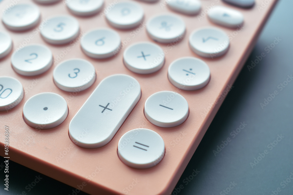 close up modern peach colour pastel calculator and white button on blue background, business and finance accounting concept close up modern peach colour pastel calculator and white button on blue background, business and finance accounting concept