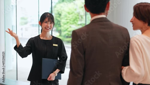 A guide in the lobby. Guests being guided at the front desk of the hotel.