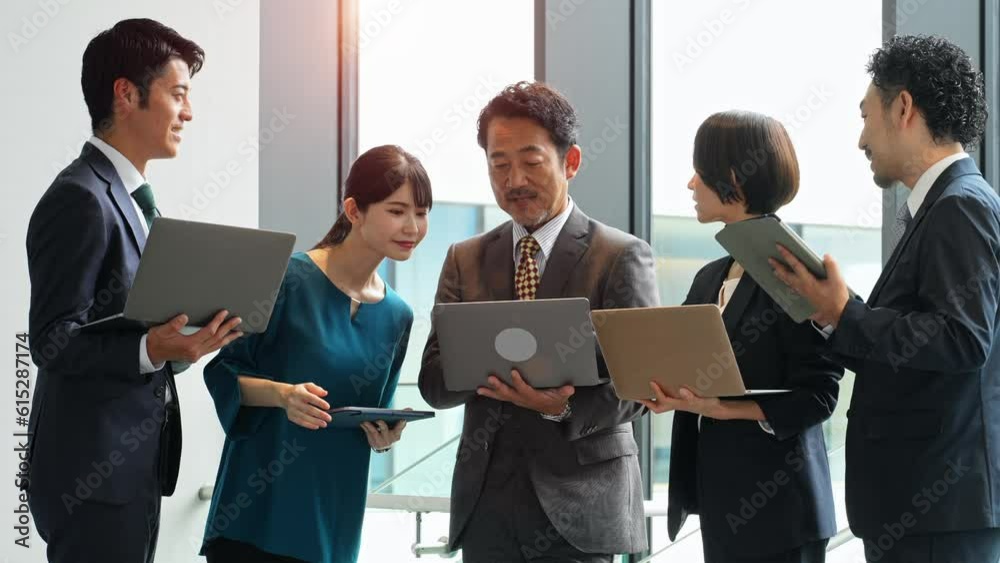 Group of Asian businesspeople meeting in lobby with laptops and tablets. Digital transformation. Smart office. Group of Asian businesspeople meeting in lobby with laptops and tablets. Digital transformation. Smart office.