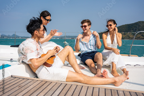 Group of diverse friend sit on deck of yacht while yachting together.
