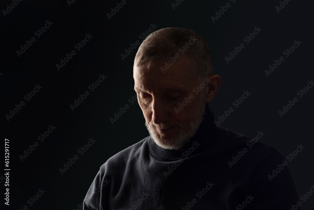portrait of a sad adult man with a white beard on a black background, close-up, selective focus