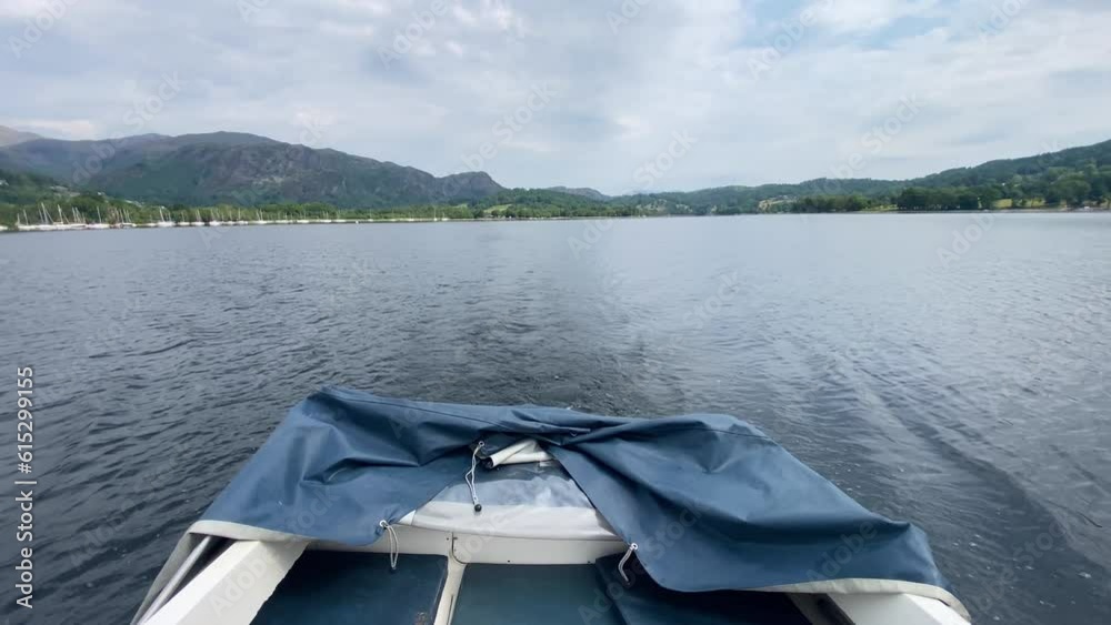 Looking out the back of a small white motor boat at a mountainous view, surrounding Coniston Water in the Lake District, UK. Cloudy but bright day. Looking out the back of a small white motor boat at a mountainous view, surrounding Coniston Water in the Lake District, UK. Cloudy but bright day.
