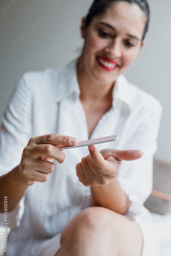 woman filing her nails at home in Mexico Latin America, hispanic people using nail file woman filing her nails at home in Mexico Latin America, hispanic people using nail file
