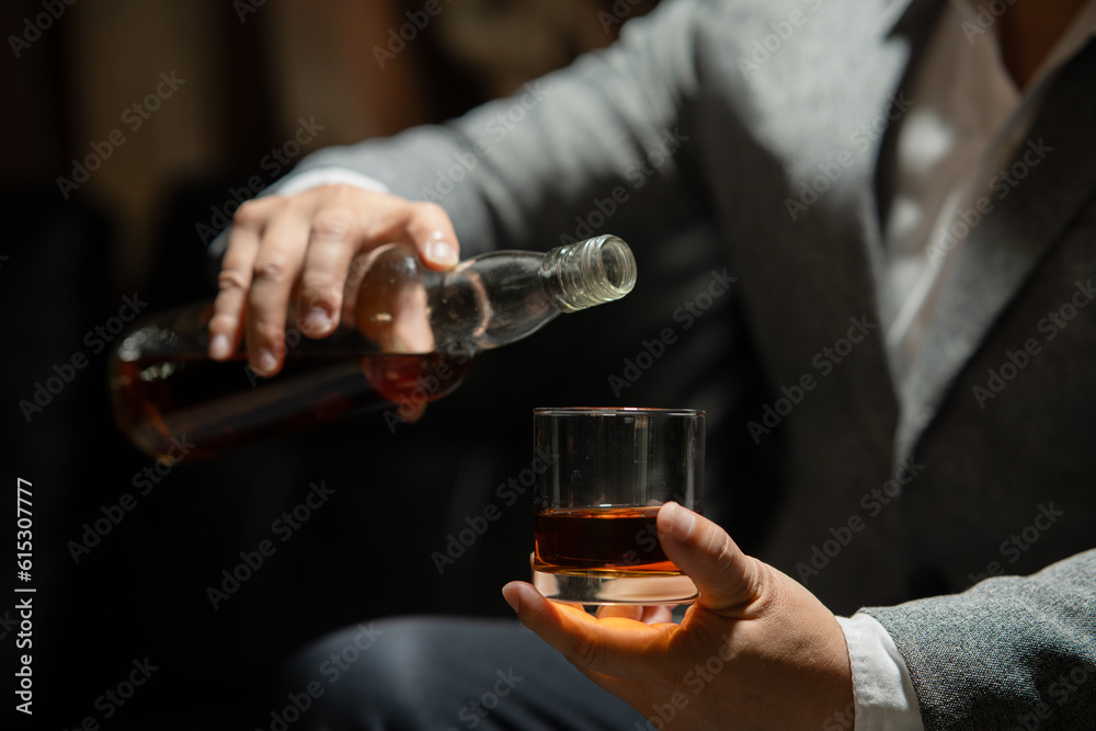 Businessman sitting Holding a Glass of Whiskey Drink Whiskey in the liquor store room Businessman sitting Holding a Glass of Whiskey Drink Whiskey in the liquor store room