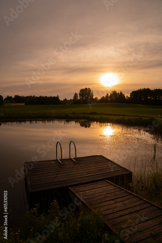 Summer sunset and water reflection in countryside