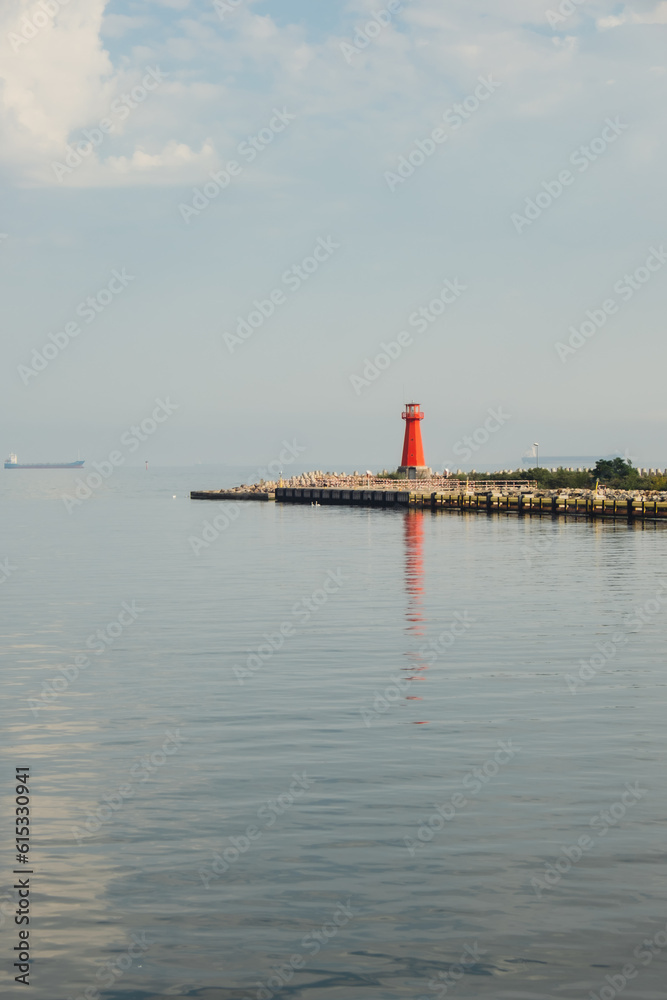 Lighthouse on blue sea line. Waves on sunny day on Baltic sea. Gdansk Poland. Swimming by ship to lighthouse. Sea water background