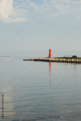 Lighthouse on blue sea line. Waves on sunny day on Baltic sea. Gdansk Poland. Swimming by ship to lighthouse. Sea water background © anna.stasiia