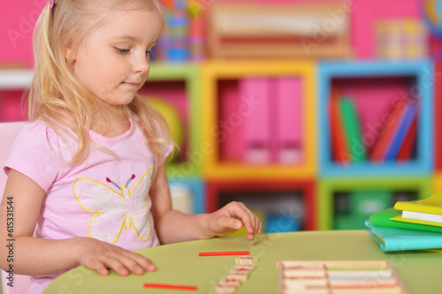 Little cute girl studying at the table at home