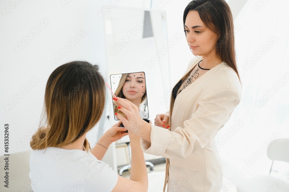 Cosmetologist applying permanent make up on eyebrows- eyebrow tattoo Cosmetologist applying permanent make up on eyebrows- eyebrow tattoo