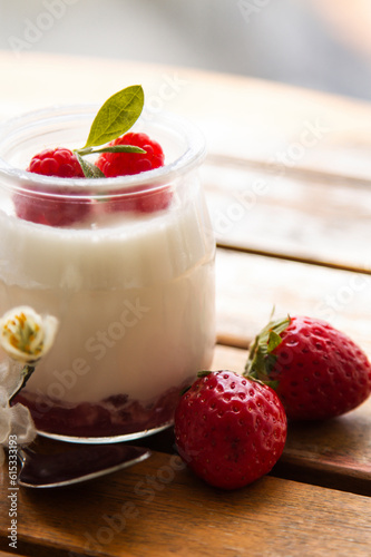Greek yogurt with strawberries on wooden background
