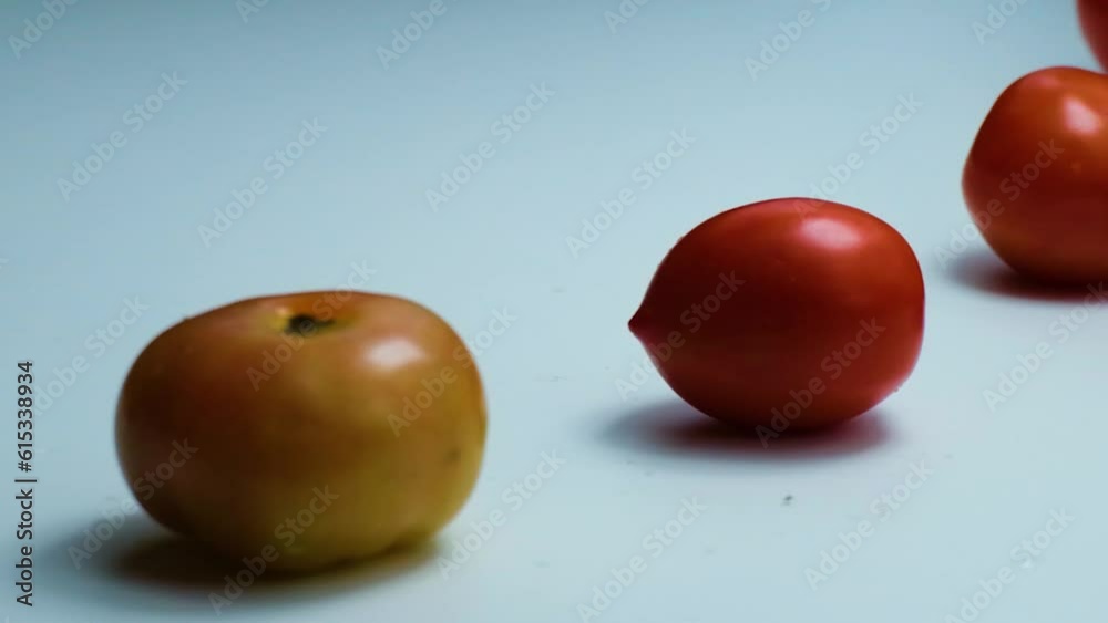 Slow motion clip of fresh red tomatoes falling on white background.Closeup Slow motion clip of fresh red tomatoes falling on white background.Closeup