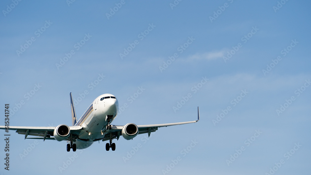 A commercial airliner coming in for landing against a clear sky with clouds. Airplane arrival. The concept of tourism, commercial air travel. A commercial airliner coming in for landing against a clear sky with clouds. Airplane arrival. The concept of tourism, commercial air travel.