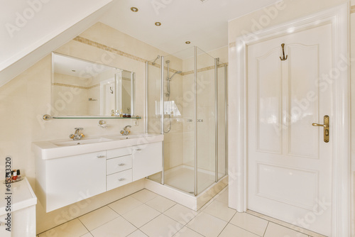 a bathroom with white tile flooring and an open door leading to the shower area in the room is very clean