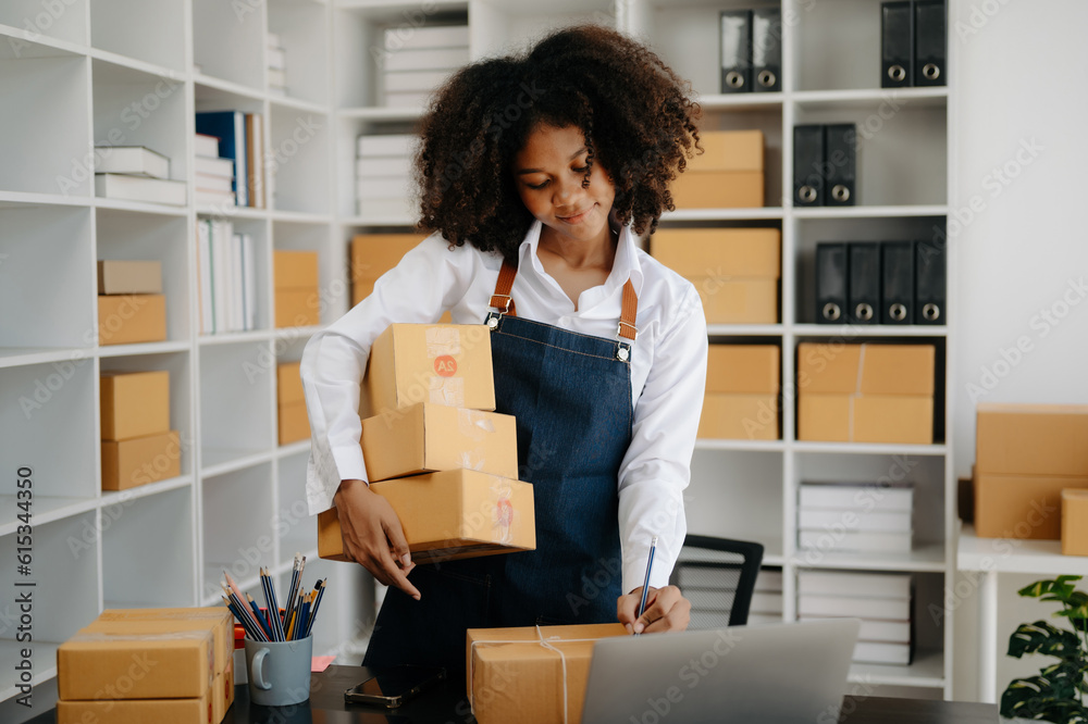 Small business entrepreneur SME freelance African woman working at home office, BOX,tablet and laptop online, marketing, packaging, delivery, e-commerce concept Small business entrepreneur SME freelance African woman working at home office, BOX,tablet and laptop online, marketing, packaging, delivery, e-commerce concept