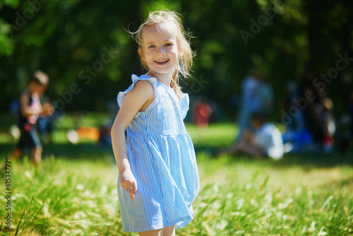 Happy cheerful preschool girl walking in park