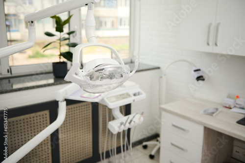 Selective focus on a dental operating lamp with directional LED light. Interior of new modern dental clinic office. Dentistry, medicine, medical equipment and stomatology concept. Medical equipment