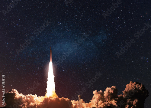 Fotografie, Obraz Modern space rocket with blast and smoke successfully takes off into starry space in the dark