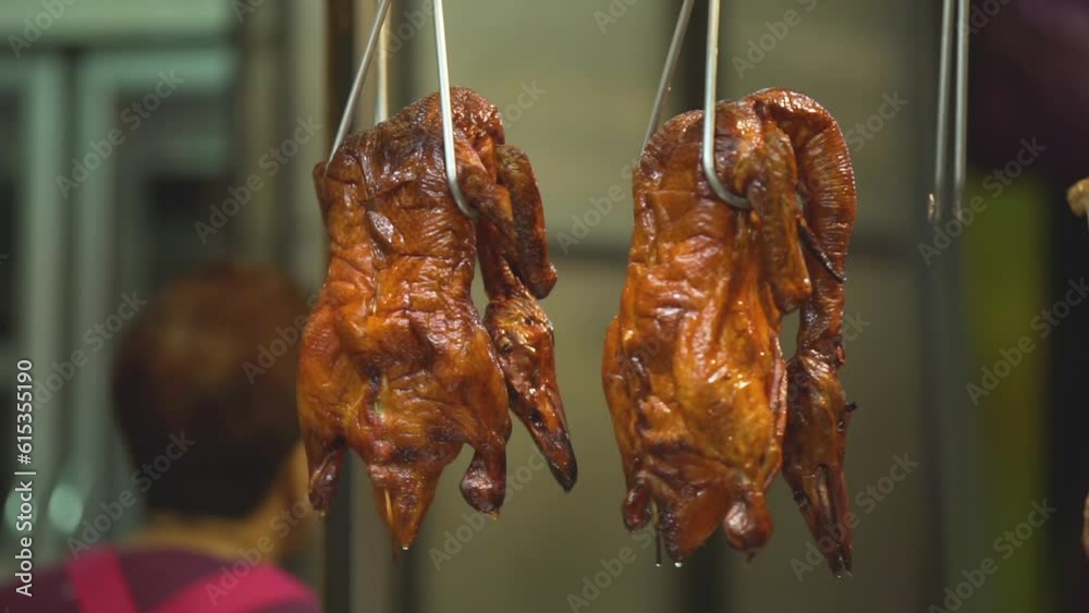 roast duck shop hangs a roast duck on an iron hook in front of the shop.