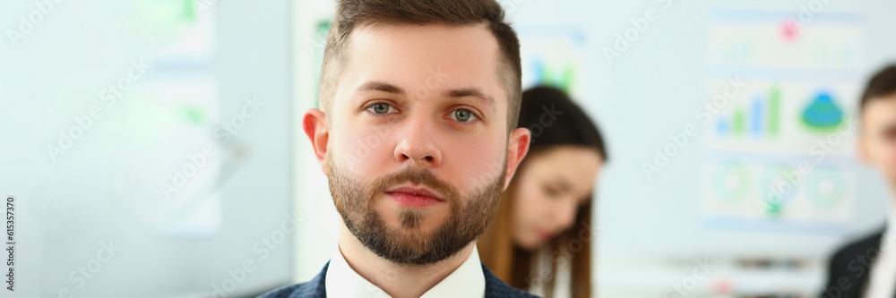 Obraz premium Portrait of serious businessman in background business partners colleagues. Successful career leader or boss in office