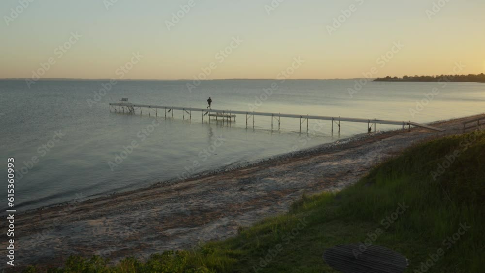 Evening Run by the Water: Woman Jogging on Empty Pier at Sunset in Slow Motion Evening Run by the Water: Woman Jogging on Empty Pier at Sunset in Slow Motion