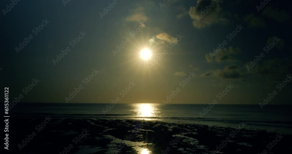 Static shot of suluban beach during a beautiful sunrise with a sun star and during low tide and water reflection Static shot of suluban beach during a beautiful sunrise with a sun star and during low tide and water reflection
