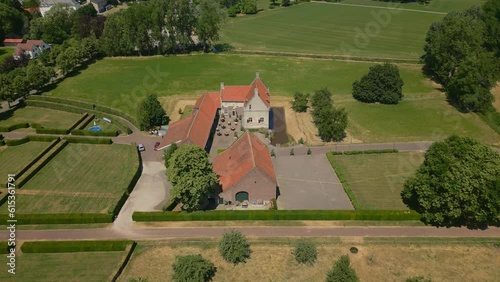 Aerial tilt up shot of Castle Farm De Grote Hegge, Thorn, Maasgouw in the province of Limburg surrounded by beautiful nature and a view of the beautiful dutch landscape photo