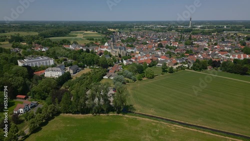 Aerial drone shot of the idyllic municipality of Thorn, Maasgouw in Limburg with a view of the beautiful green and flat landscape, the houses in Dutch architecture and the church tower on a sunny day photo