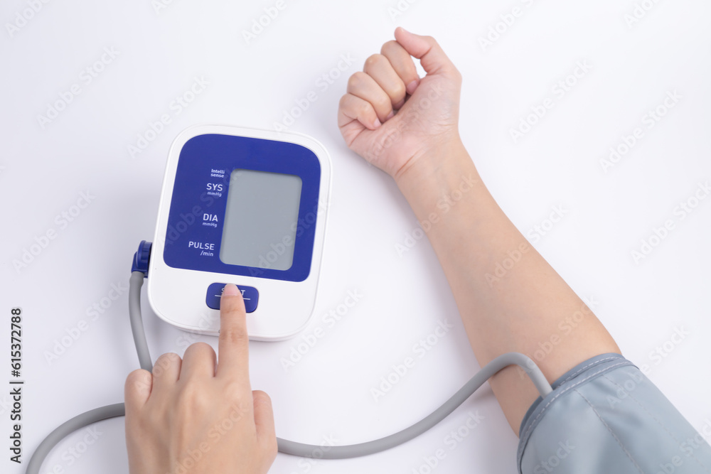 A woman hands press button on digital blood-pressure meter for health monitor by herself, heart rate check. healthcare and medical concept. A woman hands press button on digital blood-pressure meter for health monitor by herself, heart rate check. healthcare and medical concept.