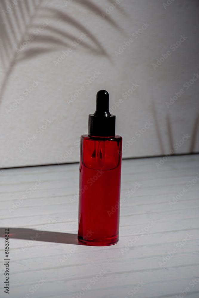A red glass dropper bottle on white background A red glass dropper bottle on white background