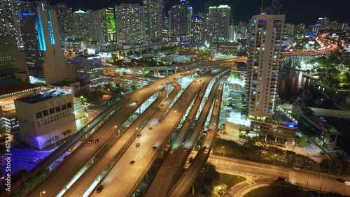 Aerial view of american highway junction at night with fast driving vehicles in Miami city, Florida. View from above of USA transportation infrastructure