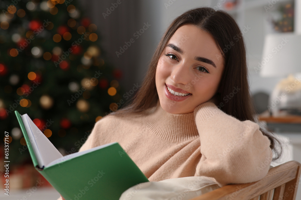 Christmas mood. Portrait of smiling woman with book indoors Christmas mood. Portrait of smiling woman with book indoors