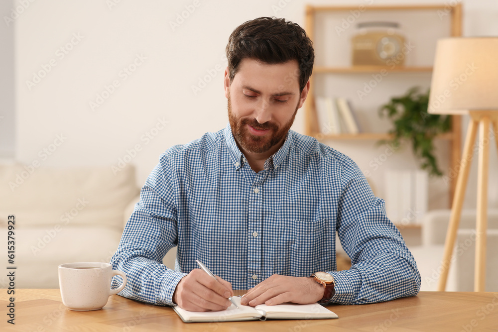 Happy man taking notes during video call at wooden desk indoors, view from camera Happy man taking notes during video call at wooden desk indoors, view from camera