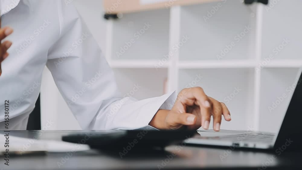 Asian Business woman using calculator and laptop for doing math finance on an office desk, tax, report, accounting, statistics, and analytical research concept Asian Business woman using calculator and laptop for doing math finance on an office desk, tax, report, accounting, statistics, and analytical research concept