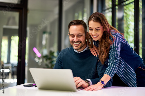 Female and male colleagues working together on a new project over a laptop.