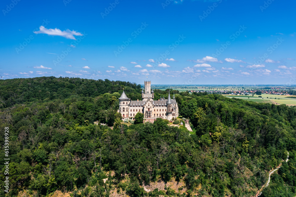 German castle Marienburg, immersed in the greenery of the forest, not far from Hannover. Aerial view of a medieval, romantic castle.
