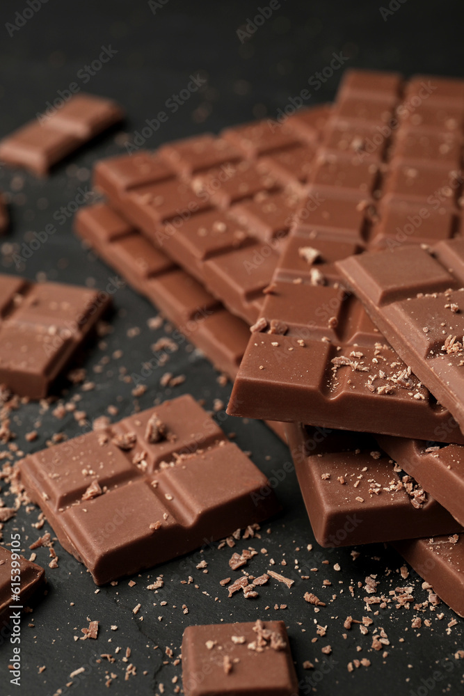 Pieces of tasty chocolate bars on grey table, closeup Pieces of tasty chocolate bars on grey table, closeup