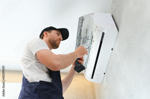 Service man is cleaning, repair and maintenance of air conditioner.