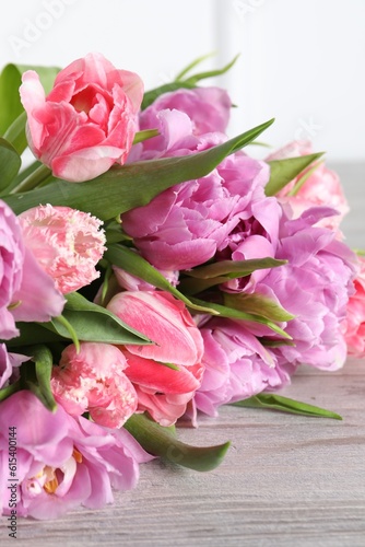 Fototapeta Naklejka Na Ścianę i Meble -  Beautiful bouquet of colorful tulip flowers on wooden table, closeup