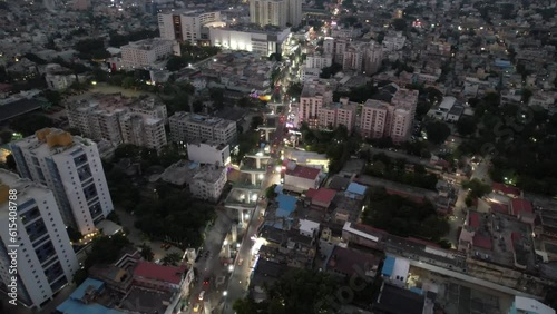 An evening aerial view of Chennai City's crowded Vadapalani Signal neighborhood reveals the city's theater, mall, congested streets, apartment buildings, and metro rail construction. photo