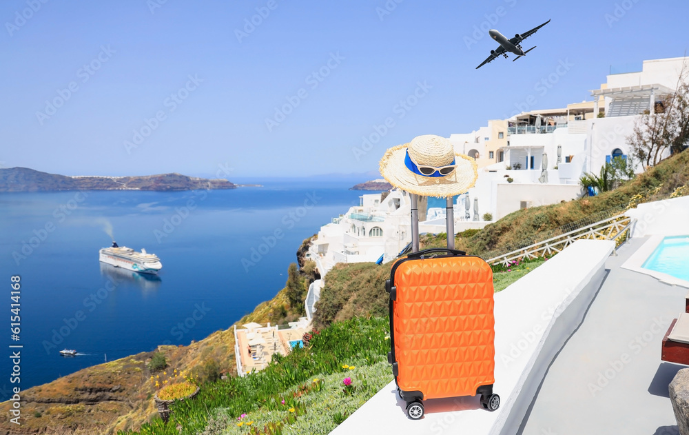 Φωτογραφία The travel concept with Orange luggage and hat as landscape view of Oia town in
