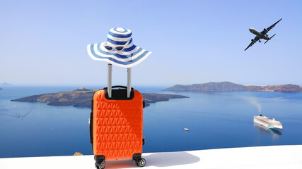 The travel concept with Orange luggage and hat as landscape view of Oia town in Santorini island in Greece